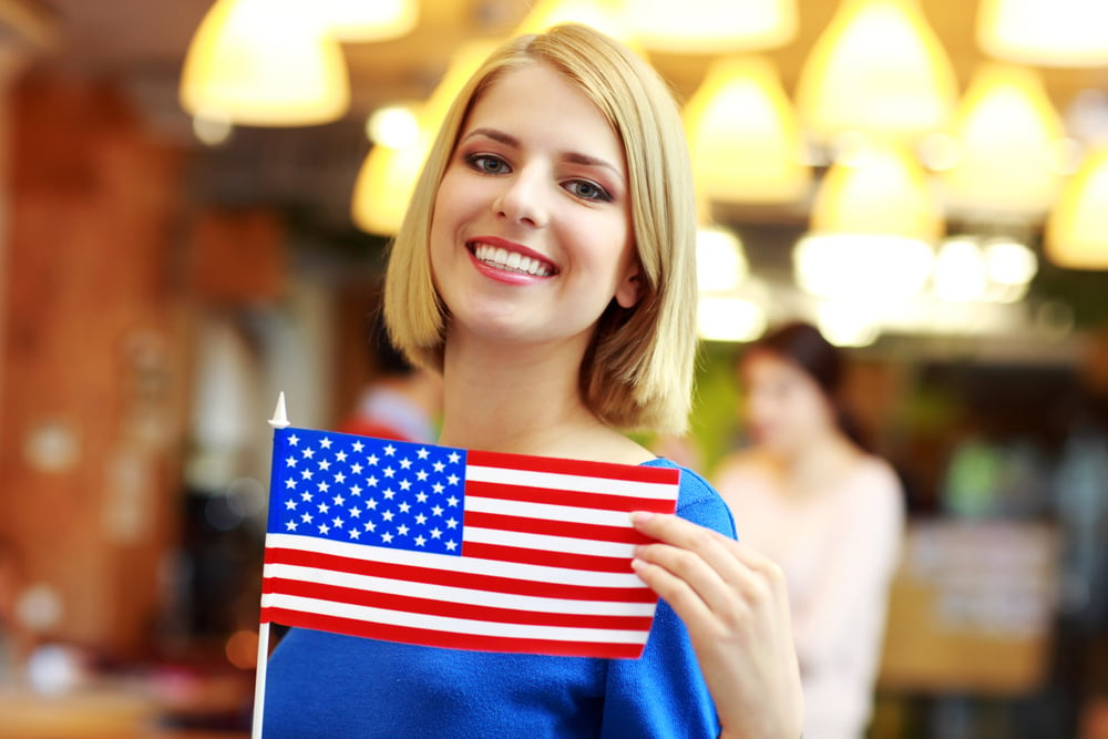 Happy girl holding flag of USA